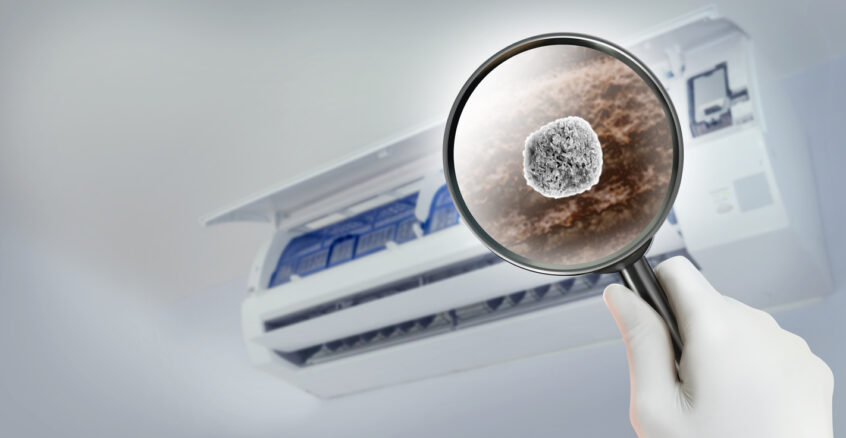 Magnifying glass showing dust and pollutant particles inside the AC system